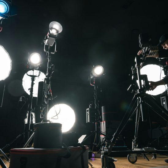 Filmmaker Adjusting Camera Lighting On Set
